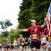 Ann Arbor resident Jonathan Algor carries an American flag as he participates in the half marathon Sunday morning during the Ann Arbor Marathon on Washtenaw Ave.Jeffrey Smith | AnnArbor.com